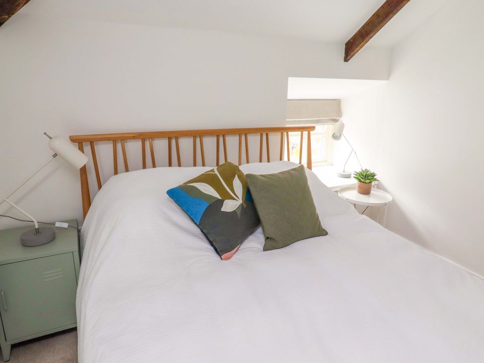 A bedroom with a bed and two lamps at Snowdrop Cottage near Warkworth