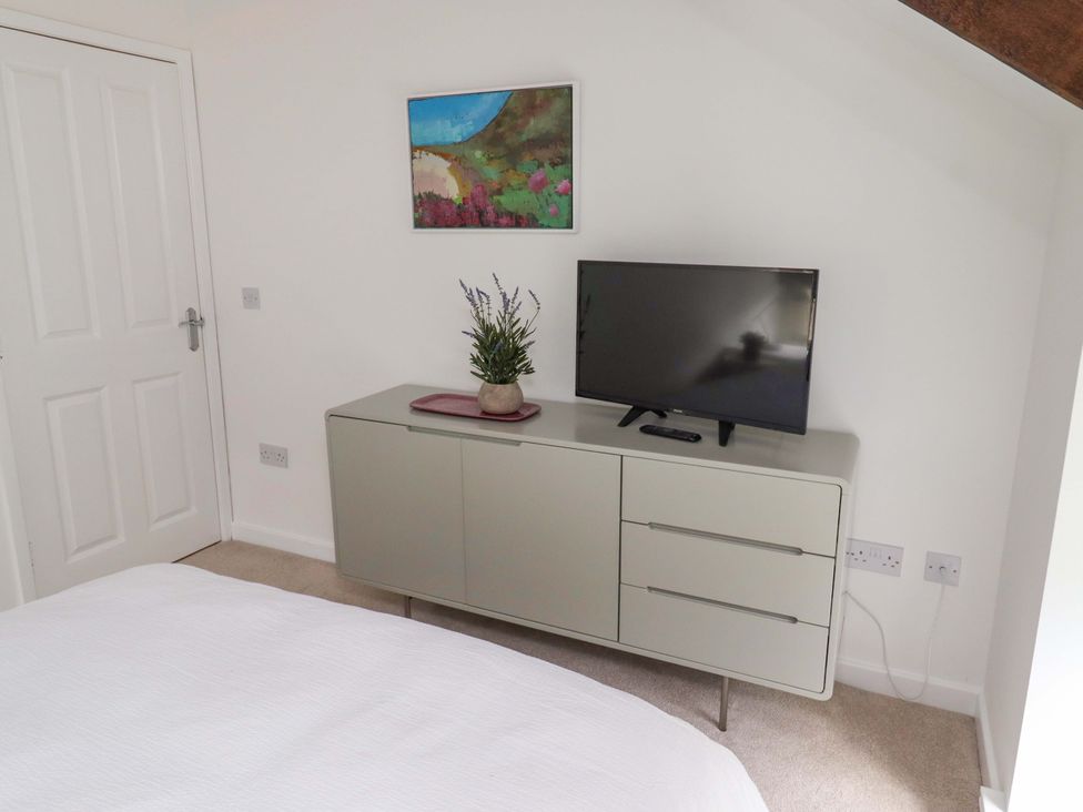 A bedroom with a television on a cabinet at Snowdrop Cottage near Warkworth