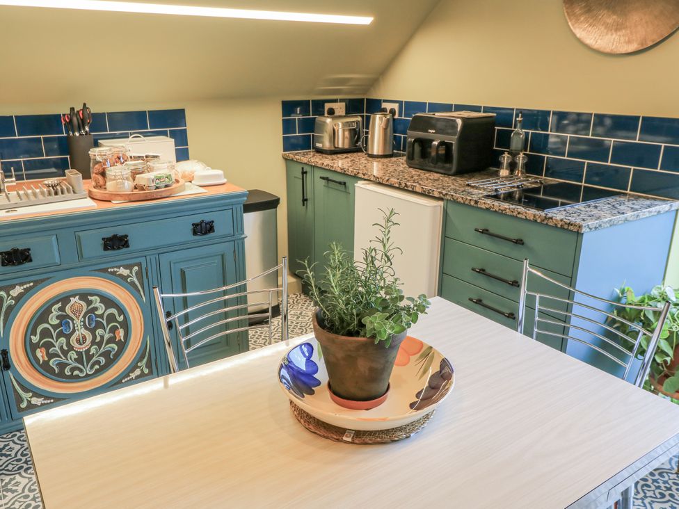 A kitchen with a table and plant at Golden Valley View in Stroud