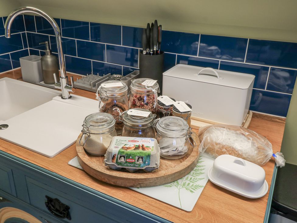 A kitchen sink with jars and food items on a cutting board at Golden Valley View in Stroud