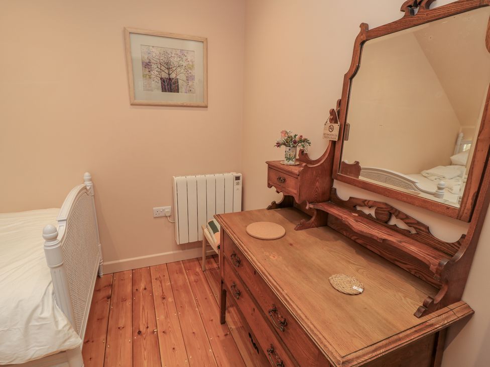 A bedroom with a bed and dressing table at Golden Valley View in Stroud