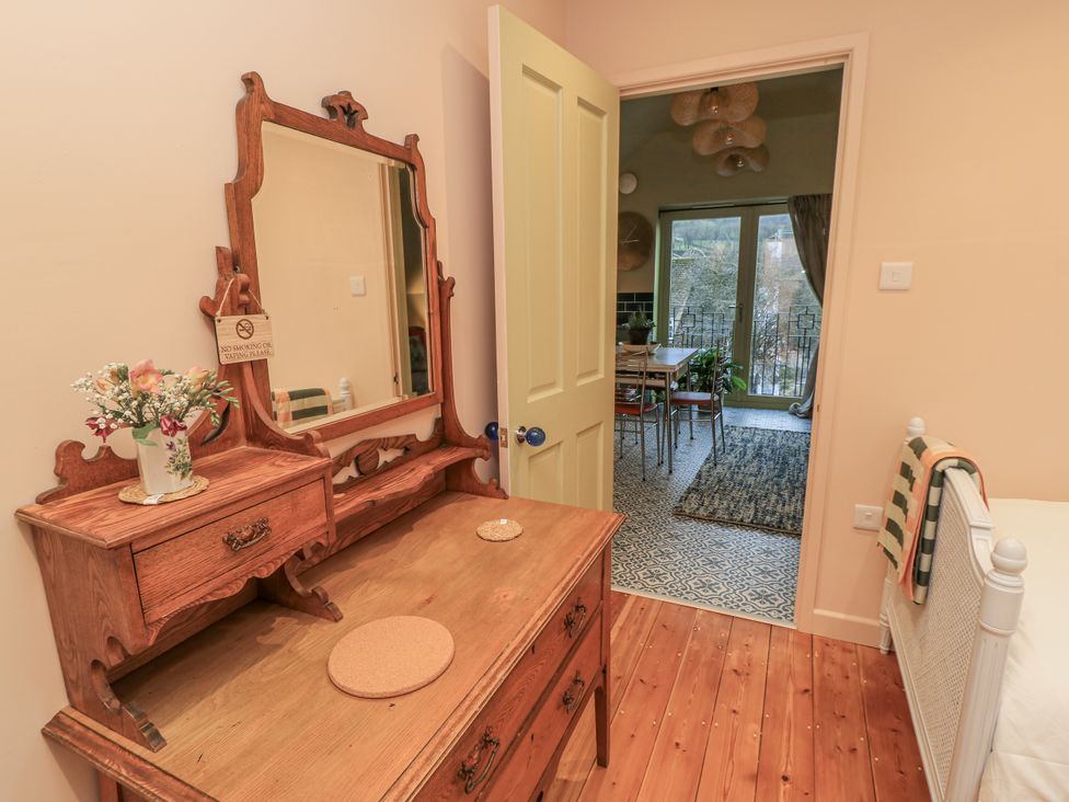 A bedroom with a vanity table and a door leading to a dining area at Golden Valley View in Stroud