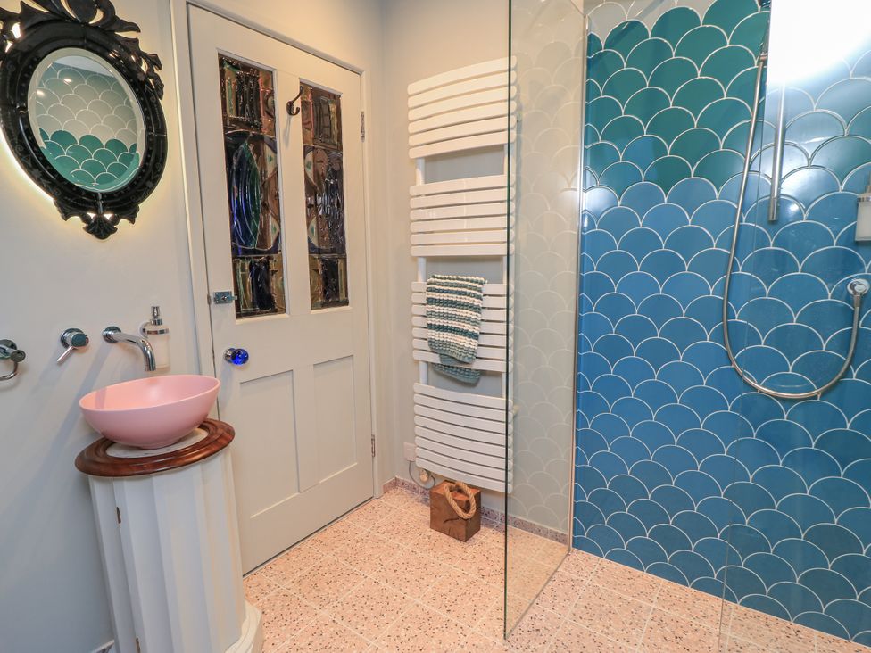 A bathroom with a sink, mirror, and shower at Golden Valley View in Stroud