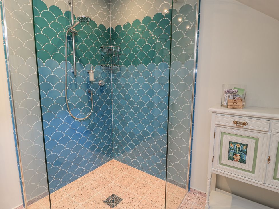 A shower with patterned tiles and a cabinet at Golden Valley View in Stroud