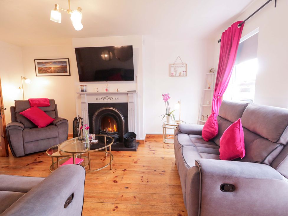 A living room with a television and a coffee table at Primrose Seaside Escape