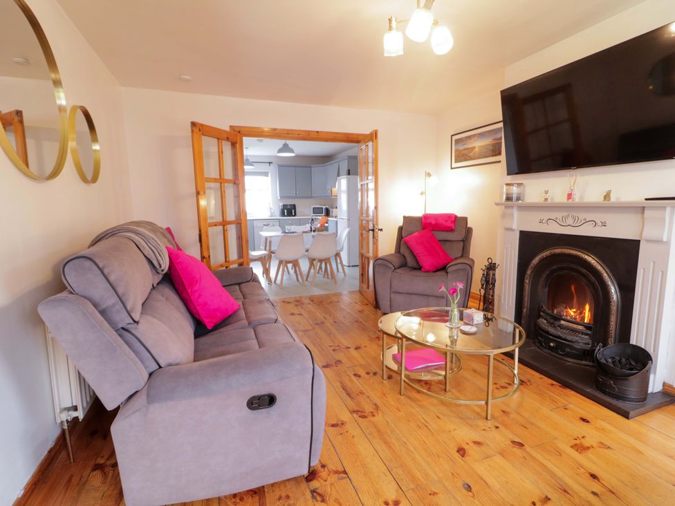 A living room with a gray sofa and a fireplace at Primrose Seaside Escape