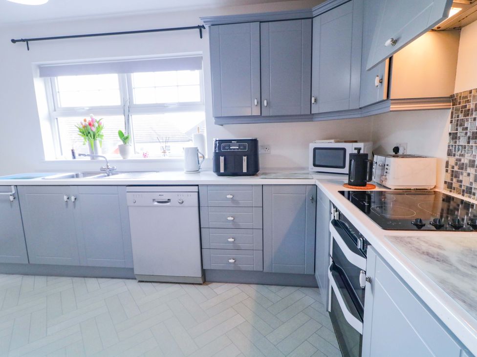 A kitchen with cabinets and appliances at Primrose Seaside Escape