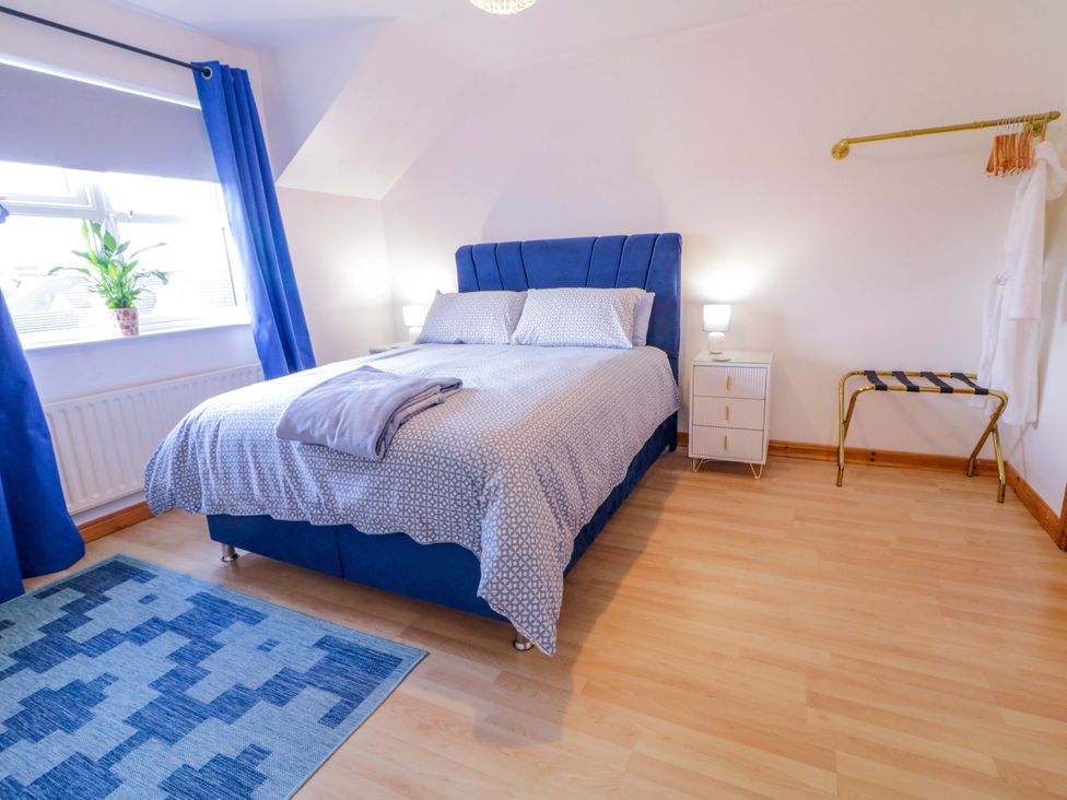 A bedroom with a bed and a nightstand at Primrose Seaside Escape