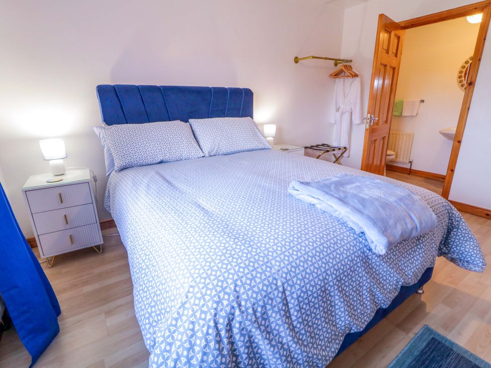 A bedroom with a bed and nightstand at Primrose Seaside Escape