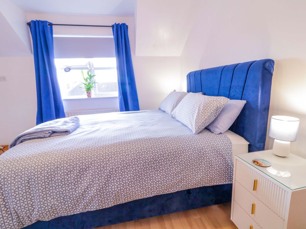 A bedroom with a bed and nightstand at Primrose Seaside Escape 