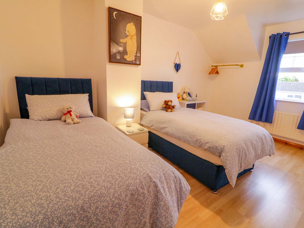 A bedroom with two beds and stuffed animals at Primrose Seaside Escape