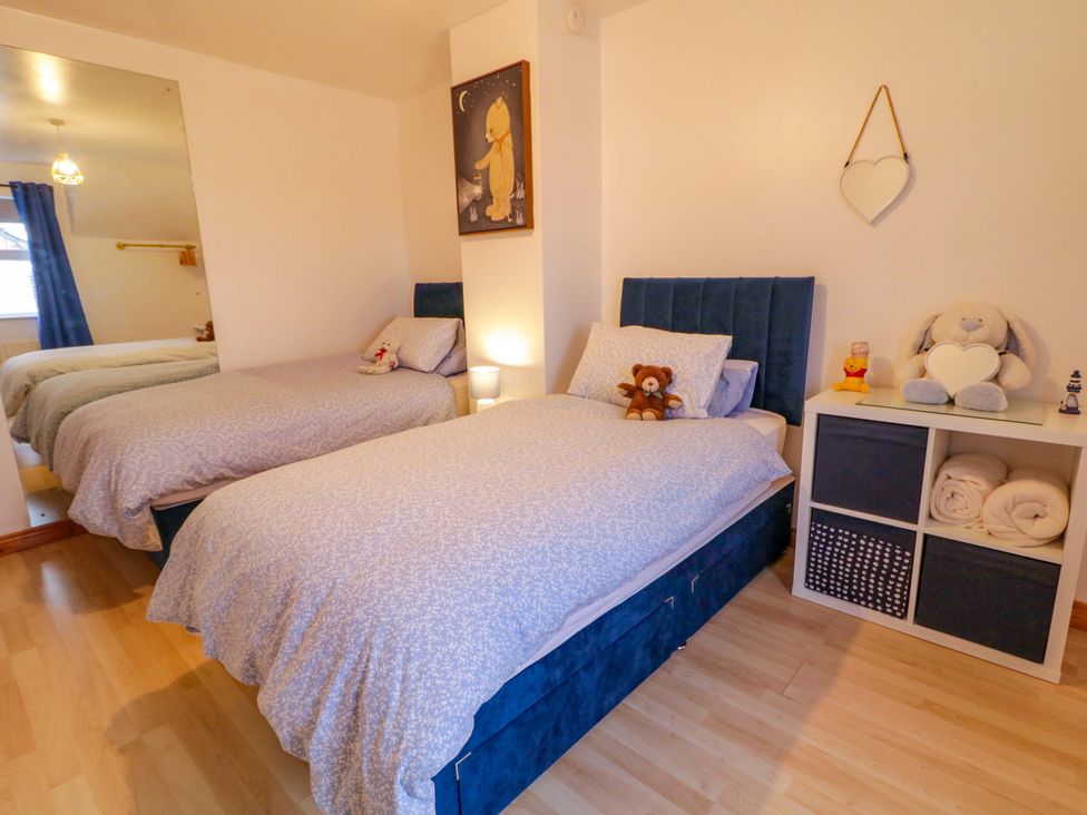 A bedroom with two beds and a nightstand at Primrose Seaside Escape