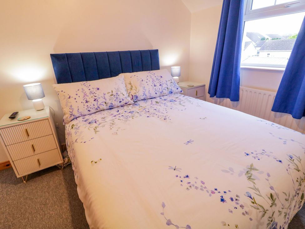 A bedroom with a bed and bedside table at Primrose Seaside Escape