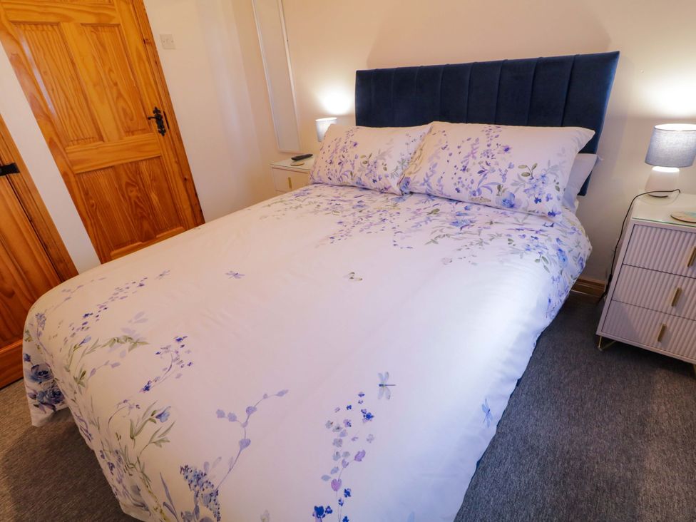 A bedroom with a bed and bedside table at Primrose Seaside Escape