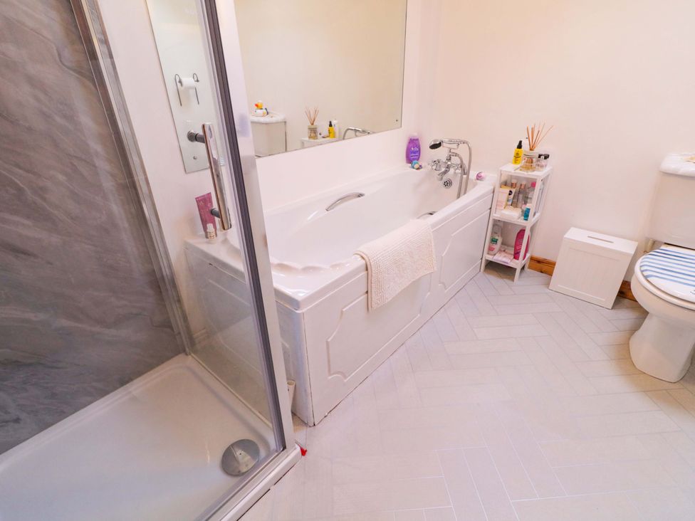 A bathroom with a bathtub and shower at Primrose Seaside Escape