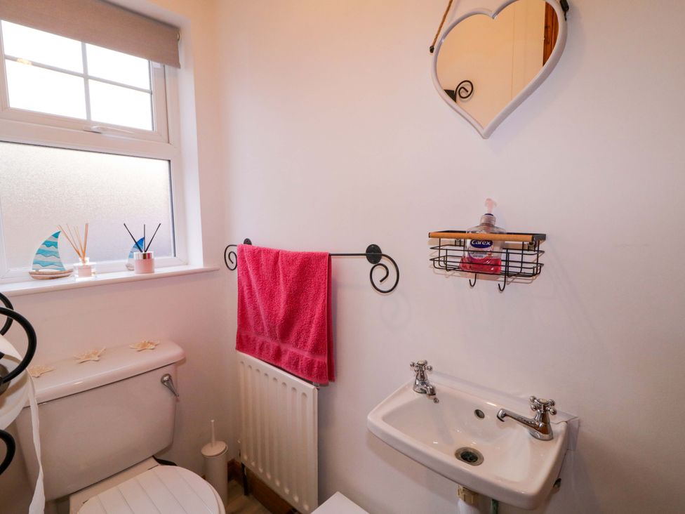 A bathroom with a sink and toilet at Primrose Seaside Escape