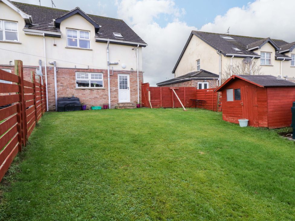 A garden with a shed and table at Primrose Seaside Escape