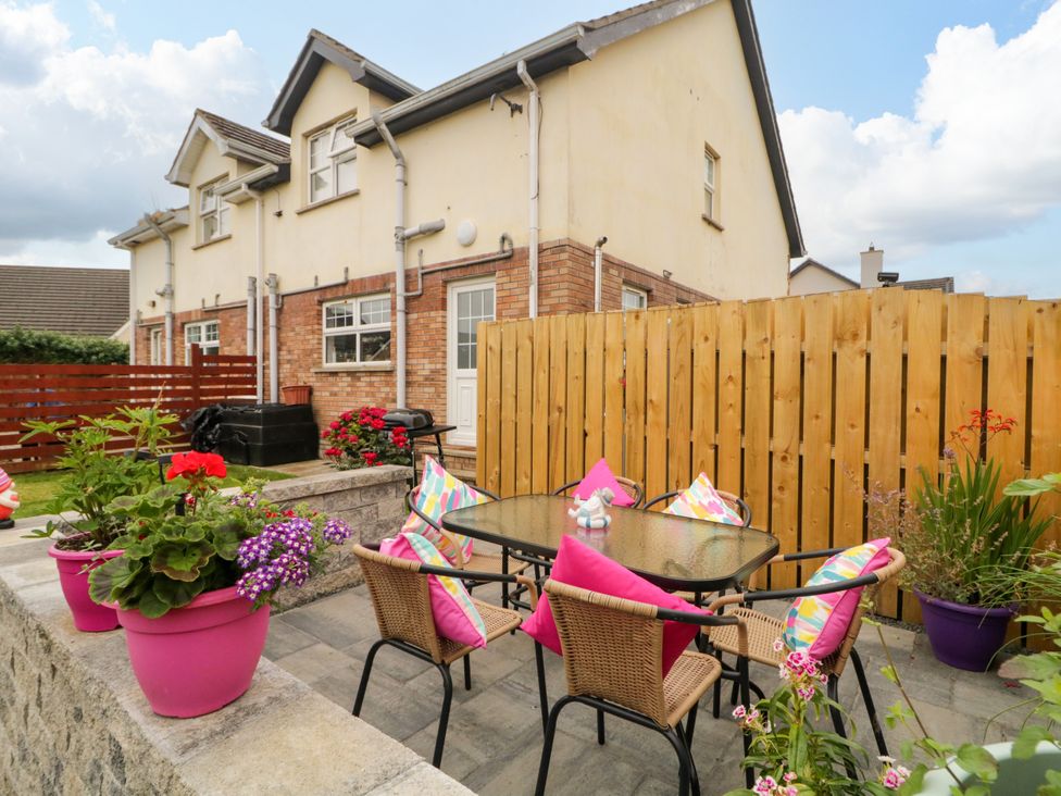 A garden with a table and chairs surrounded by flowers at Primrose Seaside Escape in Portrush, County Antrim