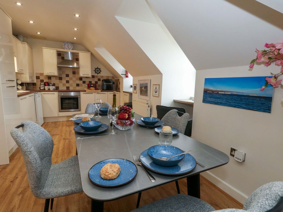 A kitchen with a dining table set for a meal at Flat 7 Weymouth