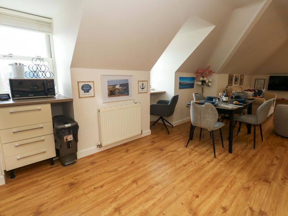 A dining area with a table and chairs at Flat 7 in Weymouth