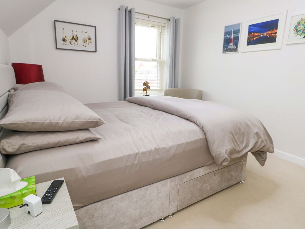 A bedroom with a bed and window at Flat 7 in Weymouth