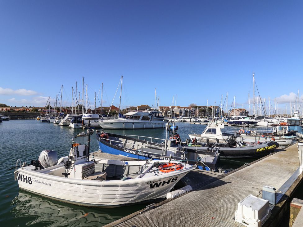 A marina with various boats and a sunny sky at Flat 7 Weymouth