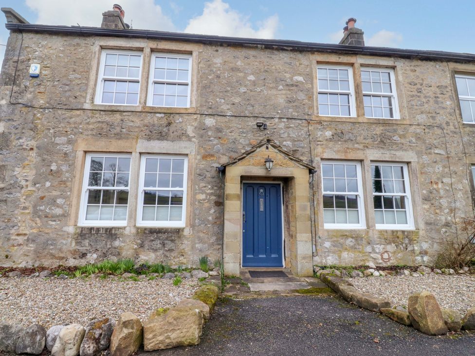 The exterior of a stone house with a blue door at Kirk Yett in Skipton