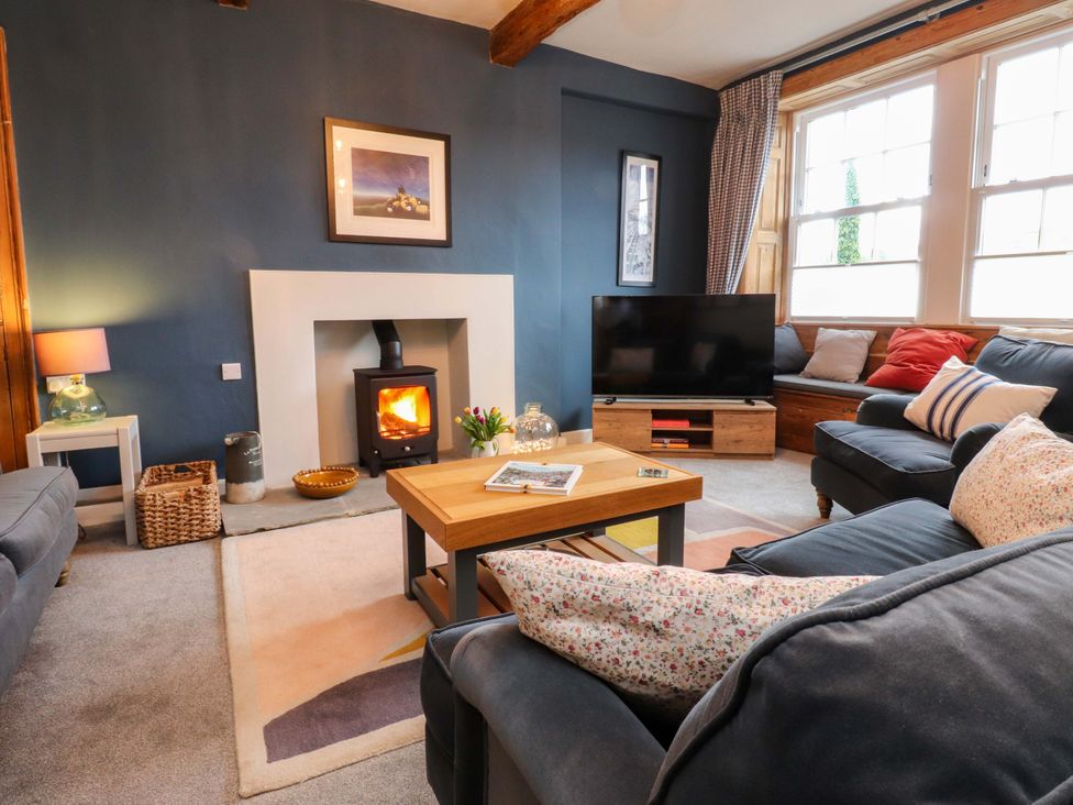 A living room with a fireplace and television at Kirk Yett in Skipton