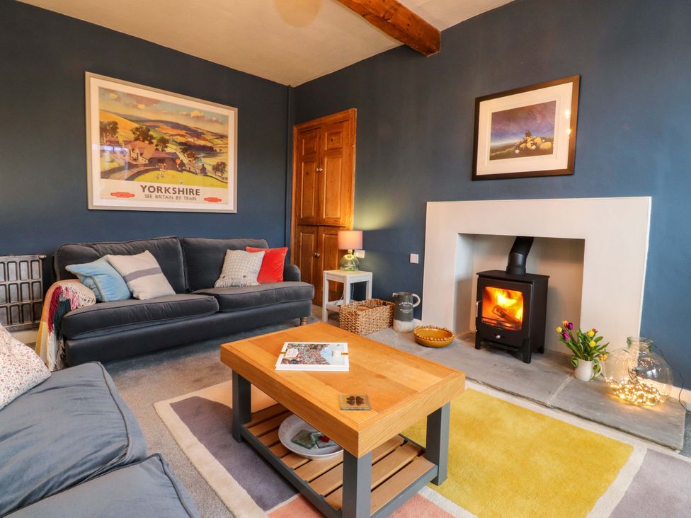 A living room with a wood stove and a coffee table at Kirk Yett in Skipton