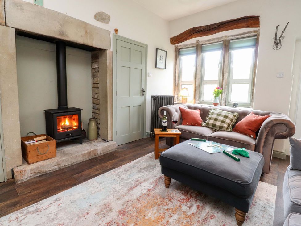 A living room with a fireplace and sofa at Kirk Yett in Skipton