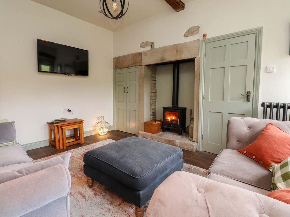 A living room with a fireplace and television at Kirk Yett in Skipton