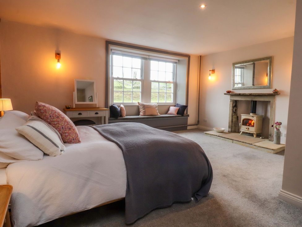 A bedroom with a bed and fireplace at Kirk Yett in Skipton