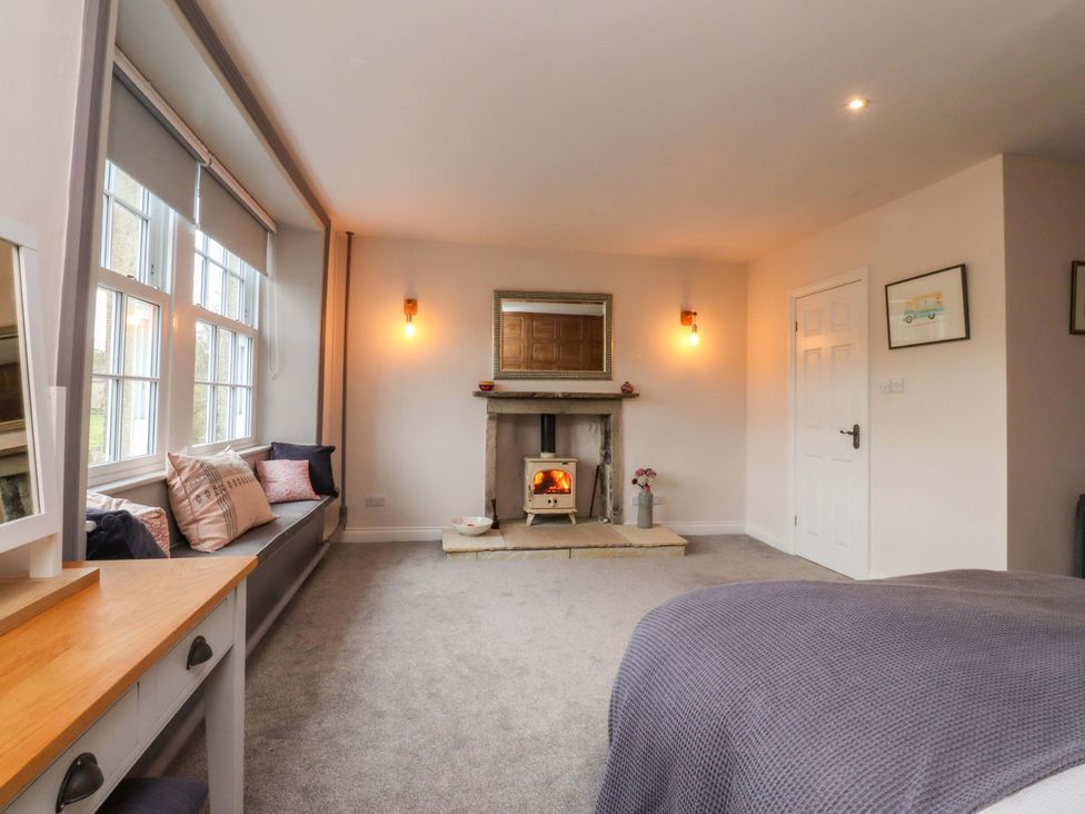 A bedroom with a fireplace and sitting area at Kirk Yett in Skipton