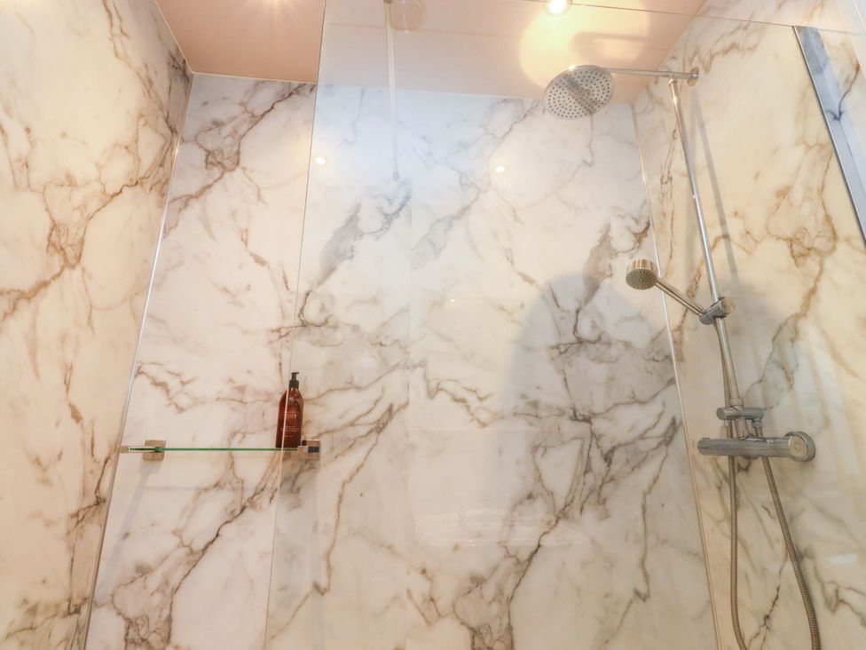 A shower with marble walls and a glass panel at Kirk Yett in Skipton