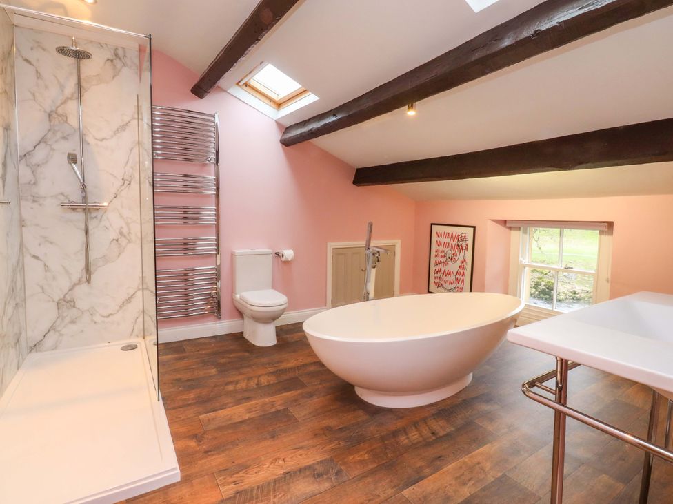A bathroom with a bathtub, shower, sink, and toilet at Kirk Yett in Skipton