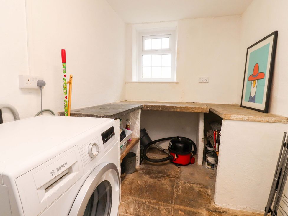 A utility room with a washing machine and vacuum cleaner at Kirk Yett in Skipton