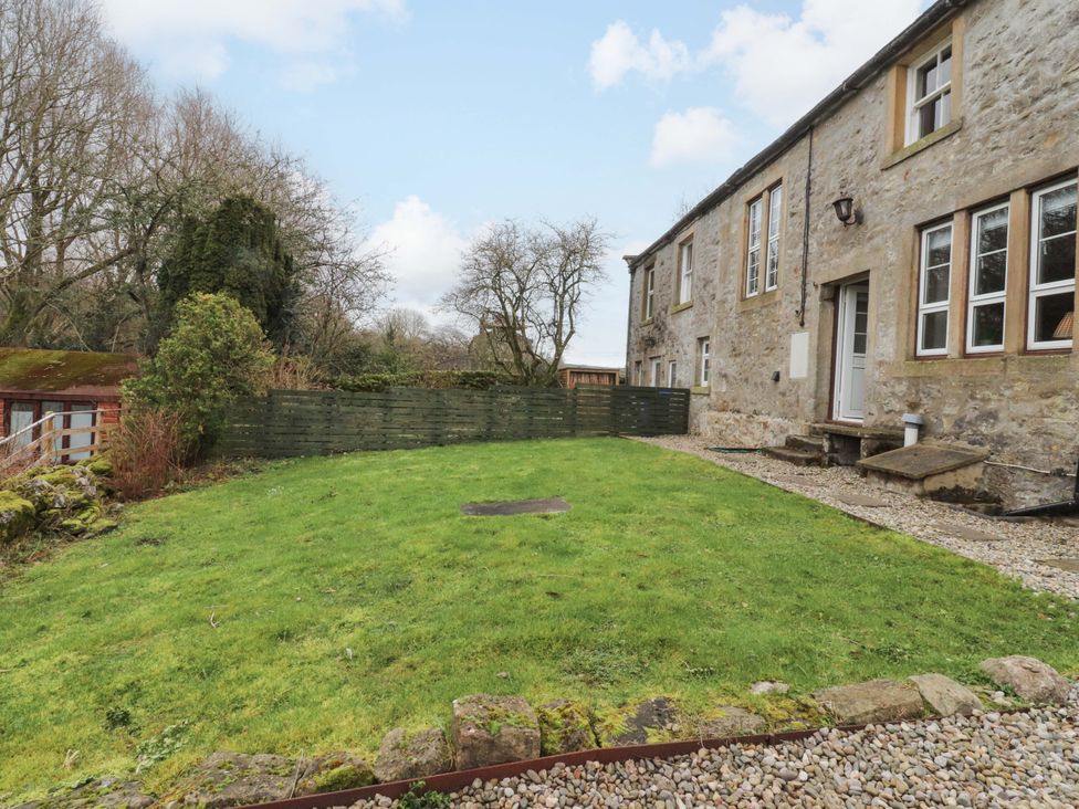 A garden area with grass and a stone path at Kirk Yett in Skipton