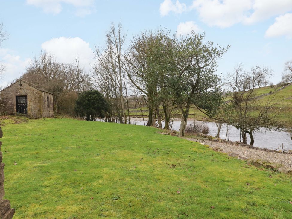 An outdoor view featuring a building near a river at Kirk Yett Skipton