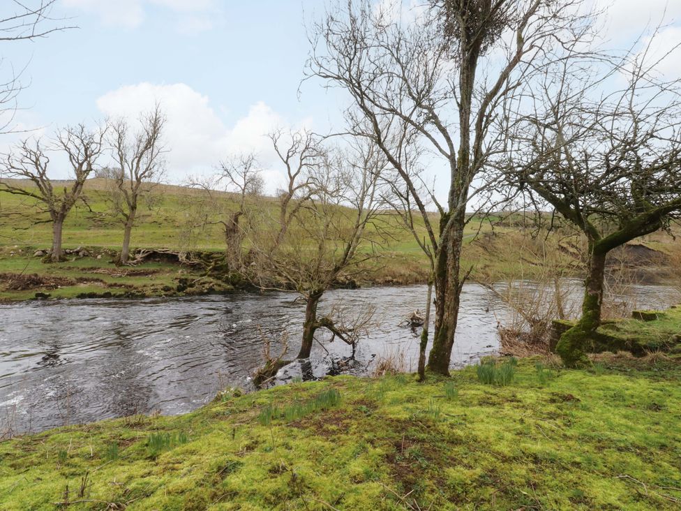 A river with trees and grass along the bank at Kirk Yett in Skipton