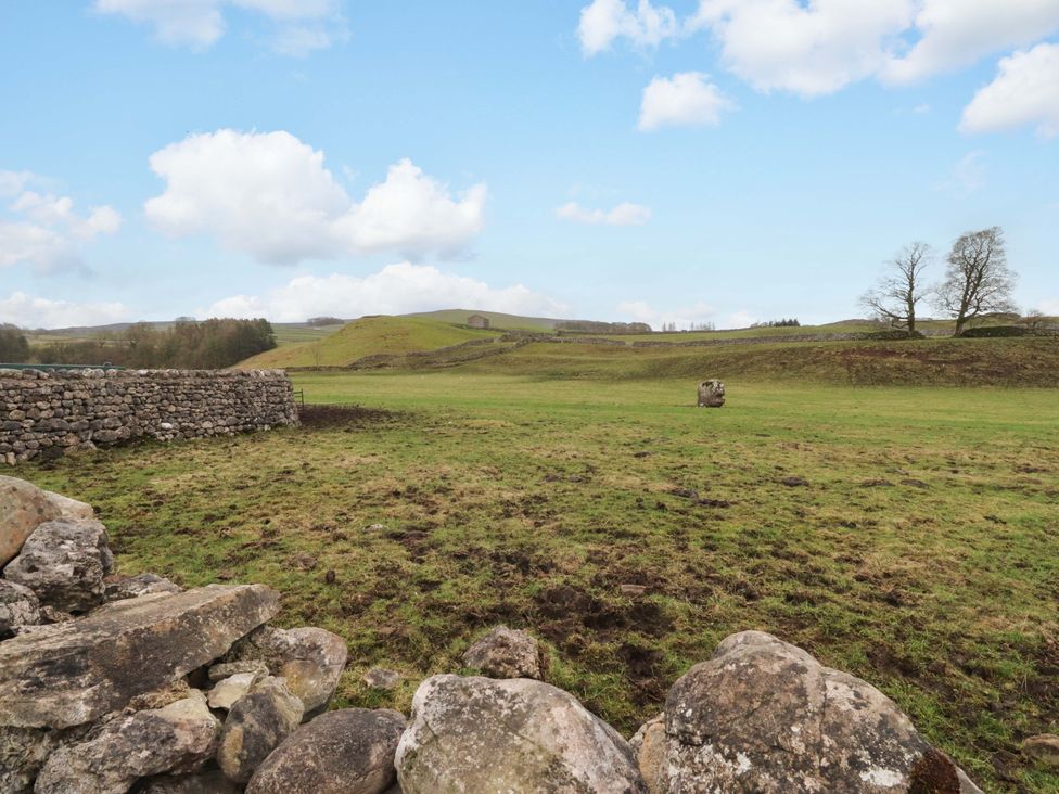 An open field with a stone wall and grass at Kirk Yett in Skipton
