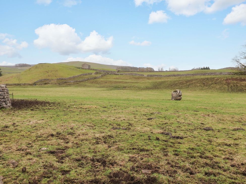 A grassy field with rocks and stone walls at Kirk Yett in Skipton