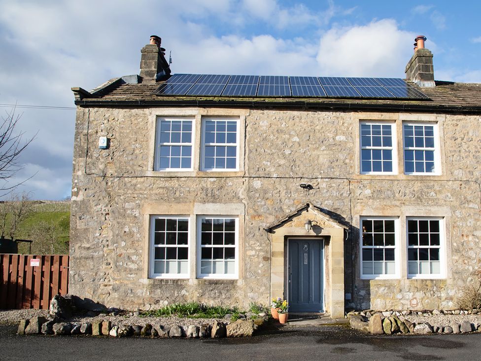 A stone house with solar panels and a garden at Kirk Yett in Linton Falls near Skipton