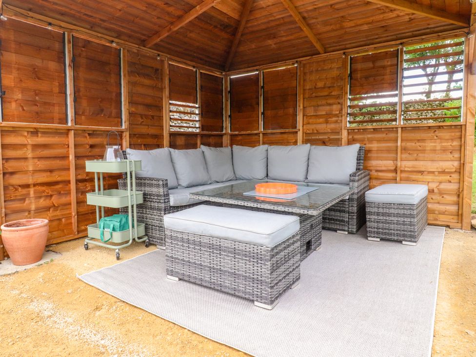 A seating area with a couch and table in a garden at Kirk Yett in Linton Falls near Skipton