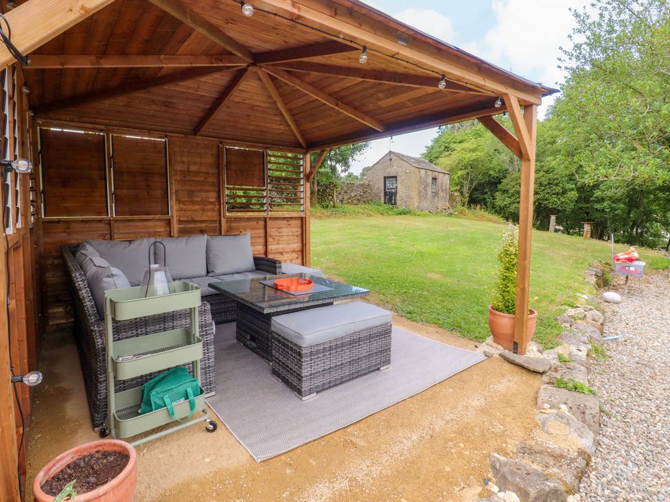 An outdoor lounge area with sofa and coffee table at Kirk Yett in Linton Falls near Skipton
