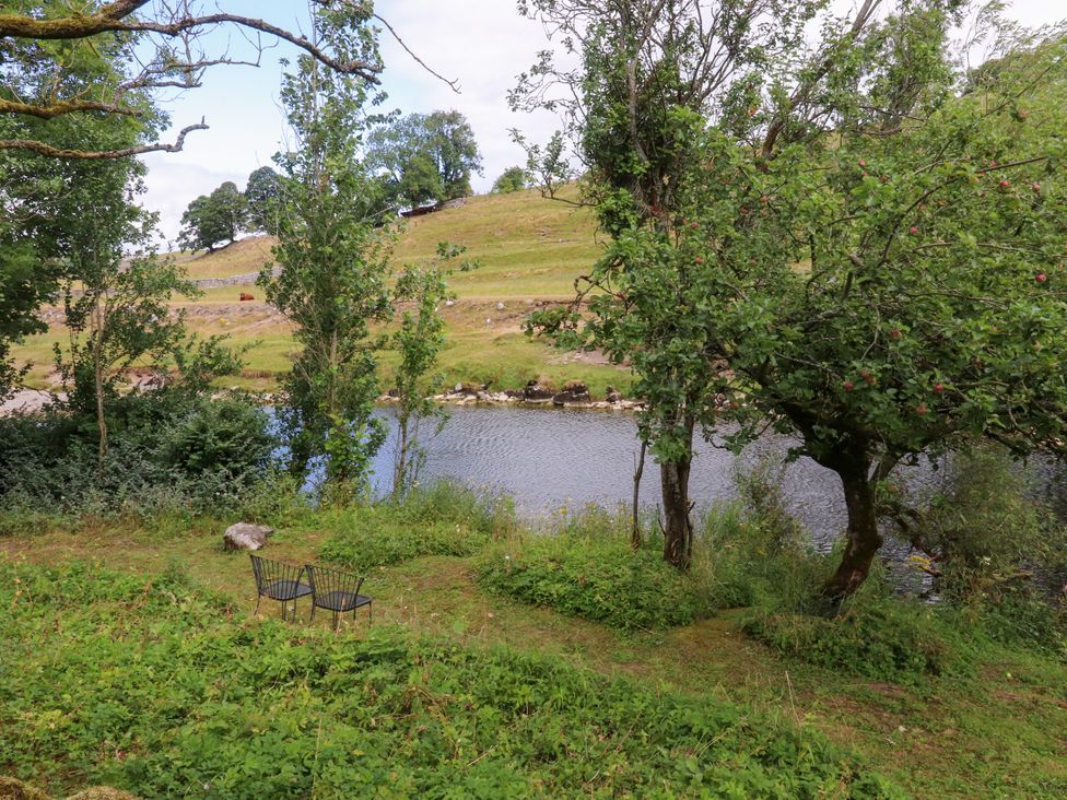 A seating area by a river at Kirk Yett in Linton Falls near Skipton