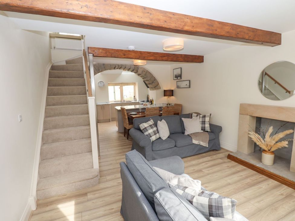 A living room with a sofa and dining area at 1 Grosvenor Farm Cottages Skipton