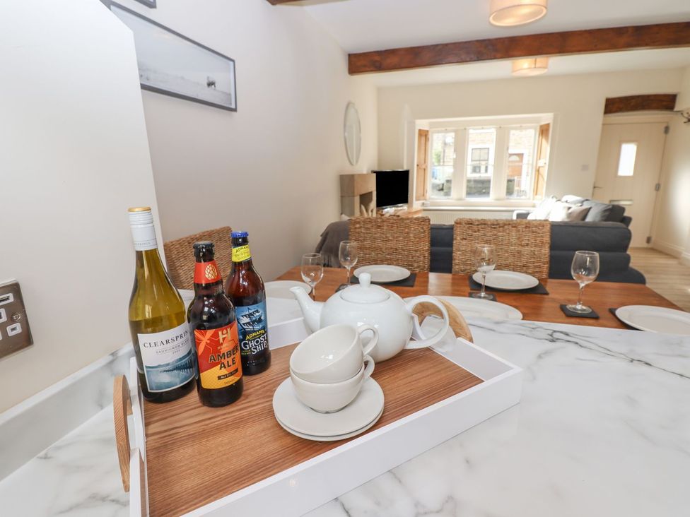 A kitchen with drinks on a tray and a dining area at 1 Grosvenor Farm Cottages Skipton