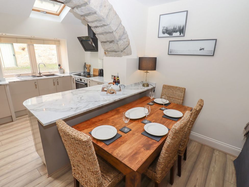 A kitchen with a dining table and chairs at 1 Grosvenor Farm Cottages in Skipton
