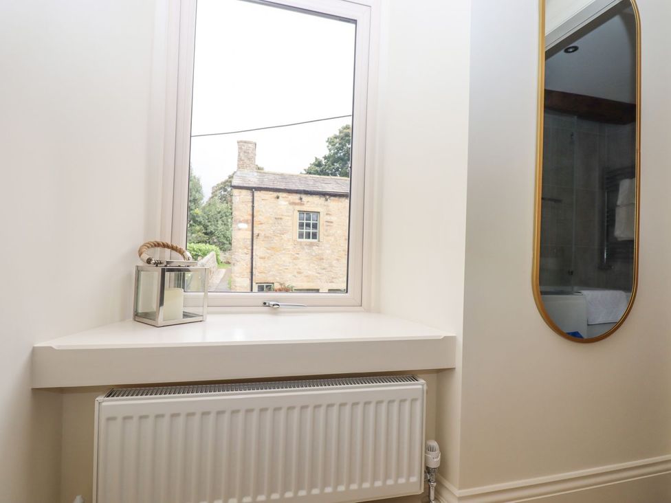 A bathroom with a window and a radiator at 1 Grosvenor Farm Cottages Skipton