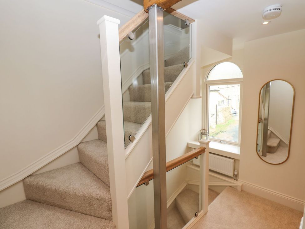 A staircase with a window and mirror at 1 Grosvenor Farm Cottages Skipton